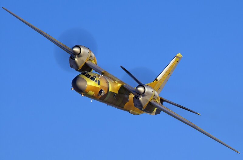 Yellow military transport plane in flight