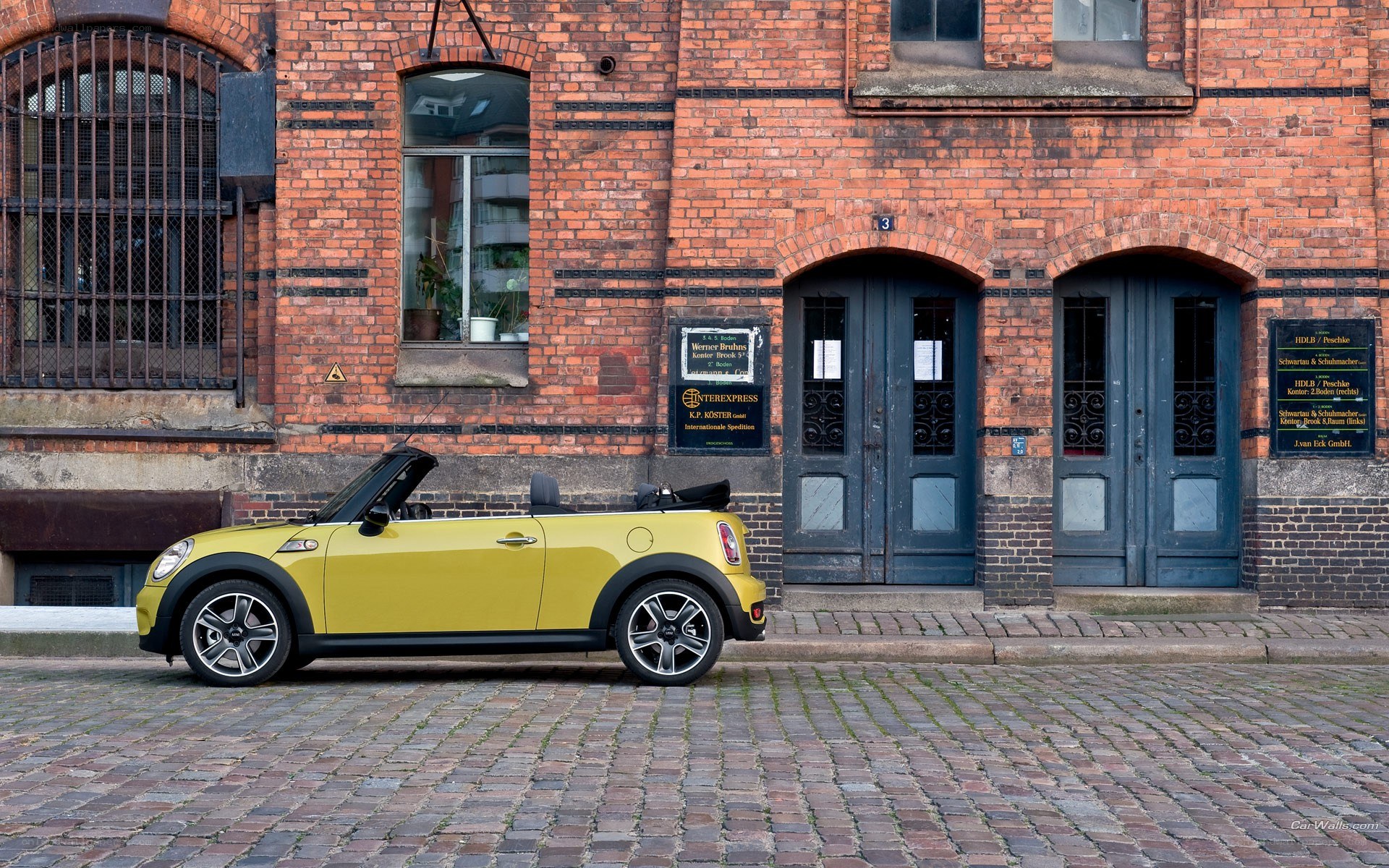 Yellow MINI convertible on cobblestones