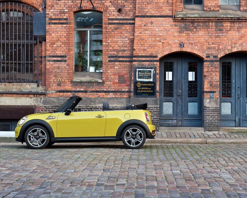 Yellow MINI convertible on cobblestones