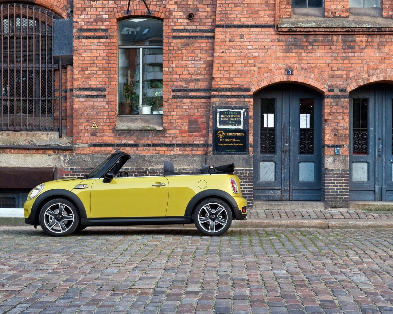 Yellow MINI convertible on cobblestones