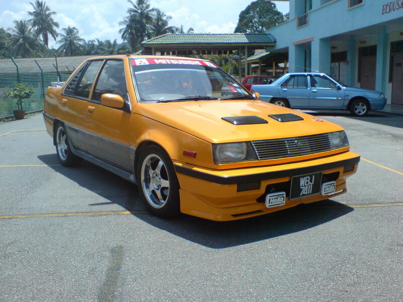 yellow mitsubishi sedan in parking lot