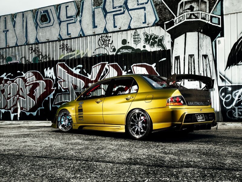 yellow modified car in graffiti alley