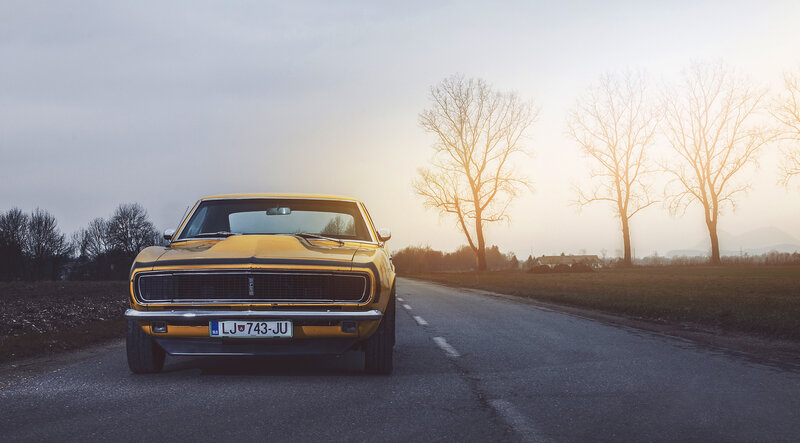 Yellow muscle car on country road