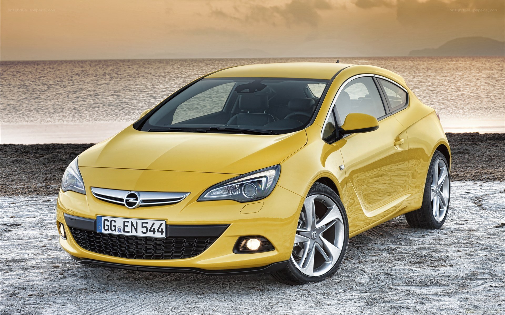 Yellow Opel Astra OPC on beach