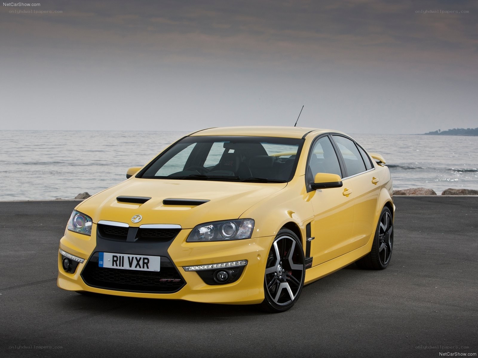 yellow performance sedan by the sea