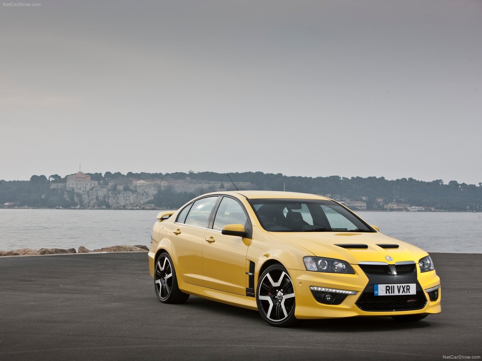 yellow performance sedan by water