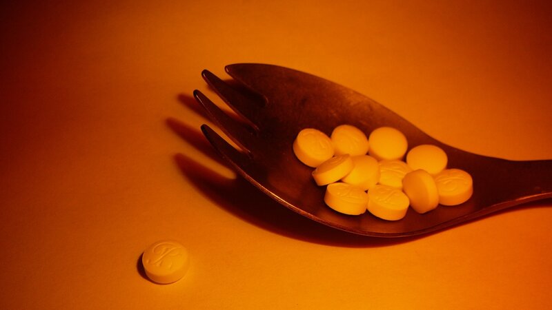Yellow pills on a fork