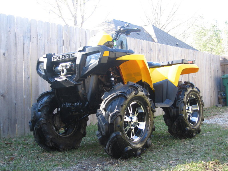 Yellow Polaris ATV in backyard