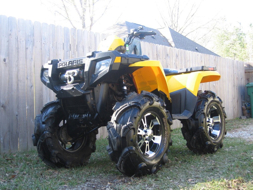 Yellow Polaris ATV in backyard