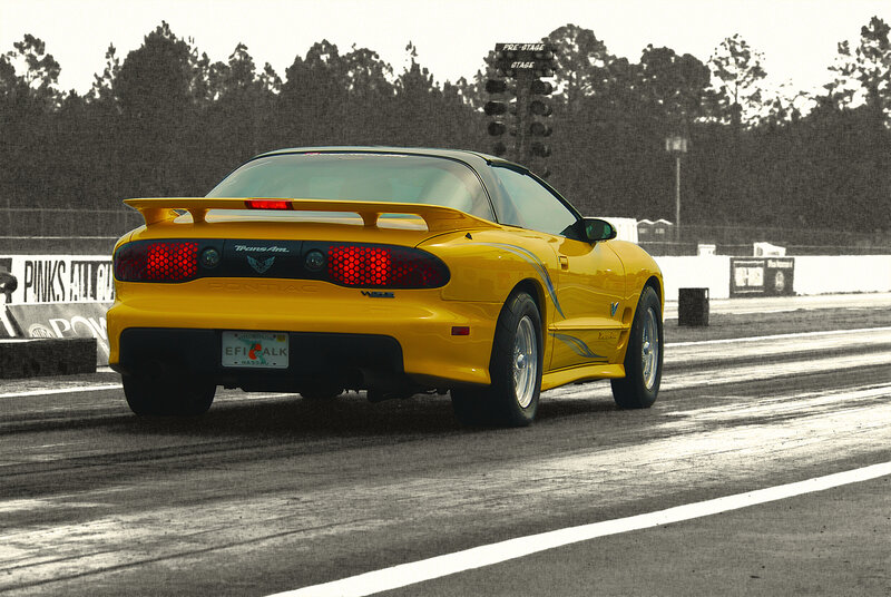 Yellow Pontiac Trans Am on a racetrack