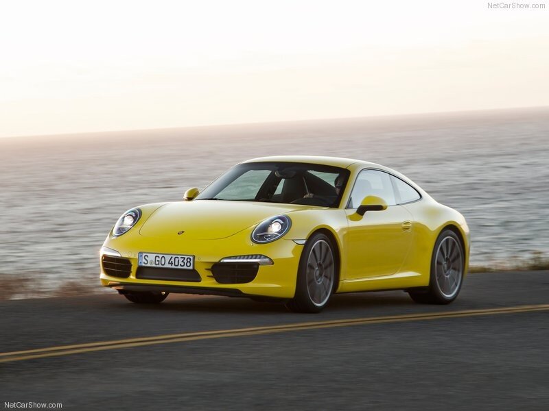 yellow porsche 911 on coastal road