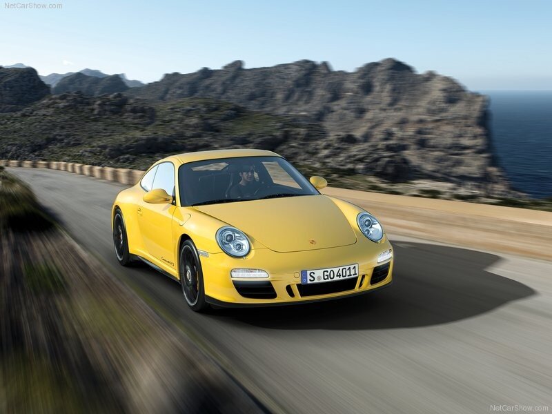 Yellow Porsche driving on coastal road