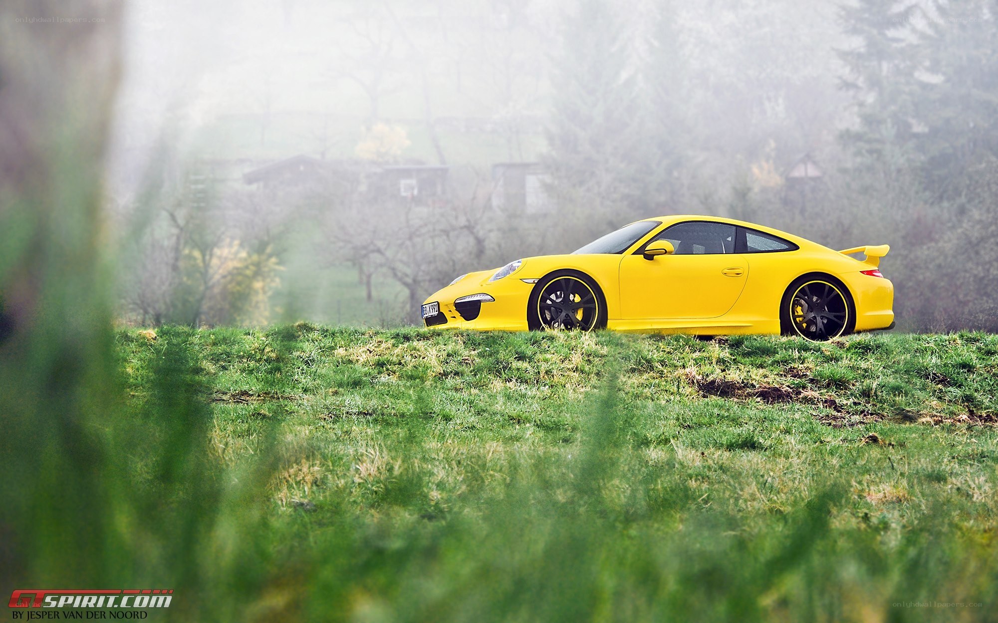 Yellow Porsche on a grassy hill