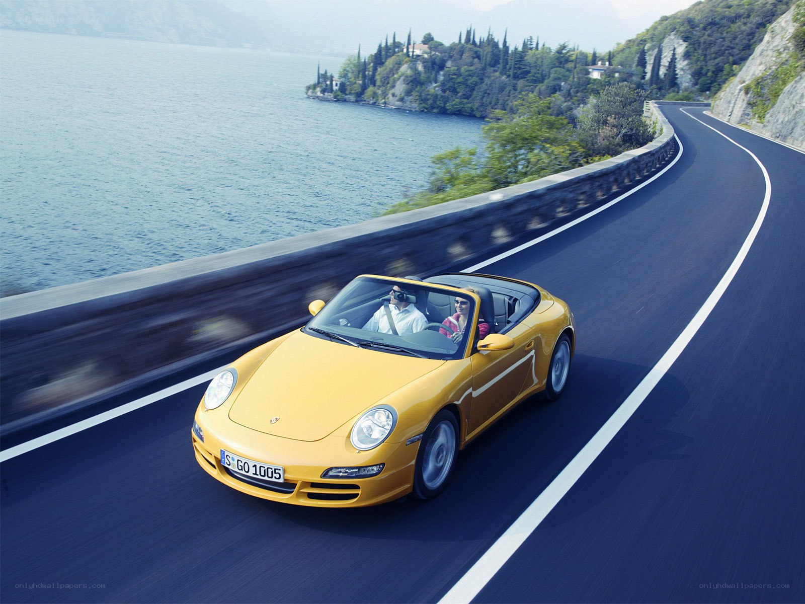 Yellow Porsche on a lakeside road