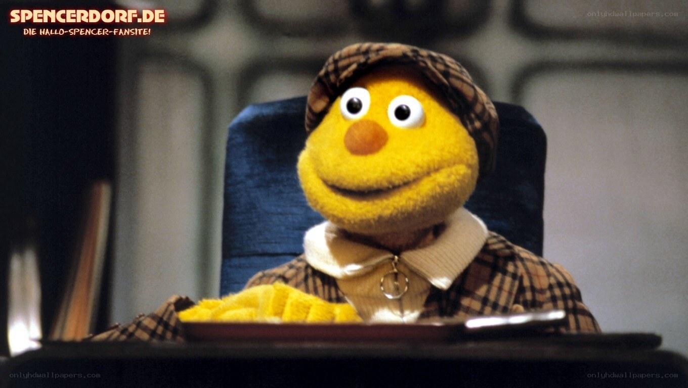 yellow puppet character at desk