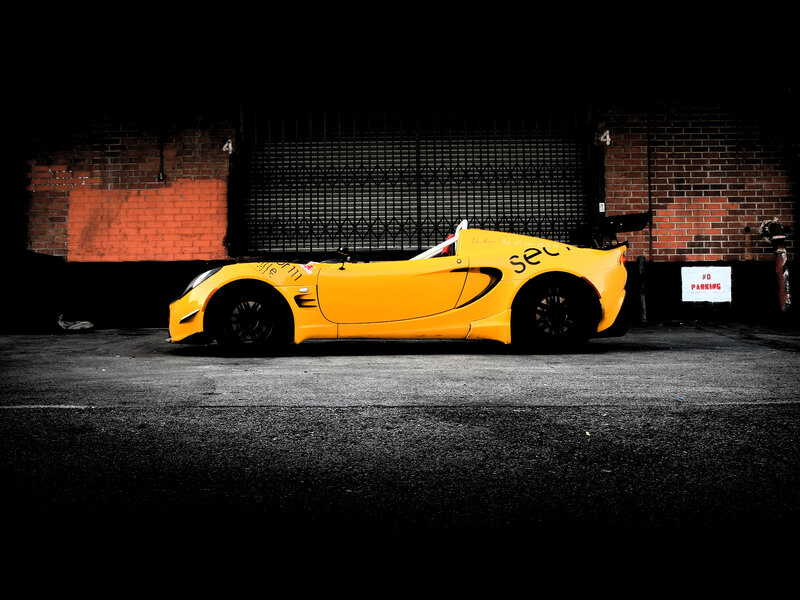 Yellow Race Car — Dramatic, Night, Photograph, Brick Wall