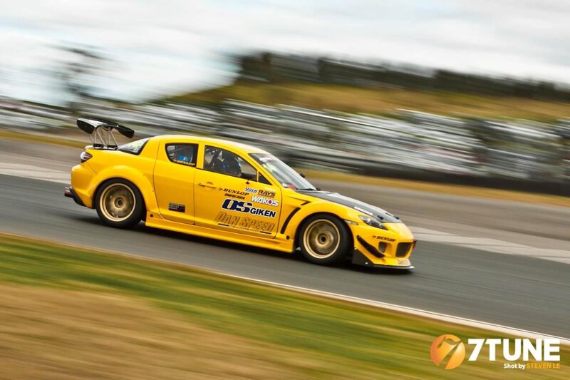 Yellow Race Car — Dynamic, Afternoon, Photograph, Race Track, Driver, Grassy Area