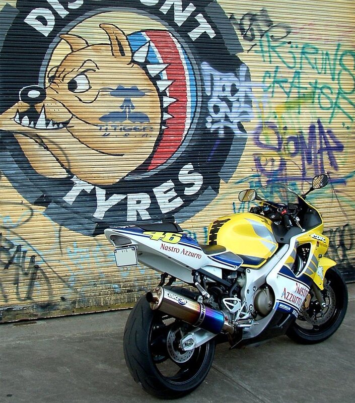 Yellow racing motorcycle in front of graffiti wall