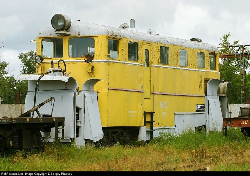 yellow rail vehicle in overgrown yard