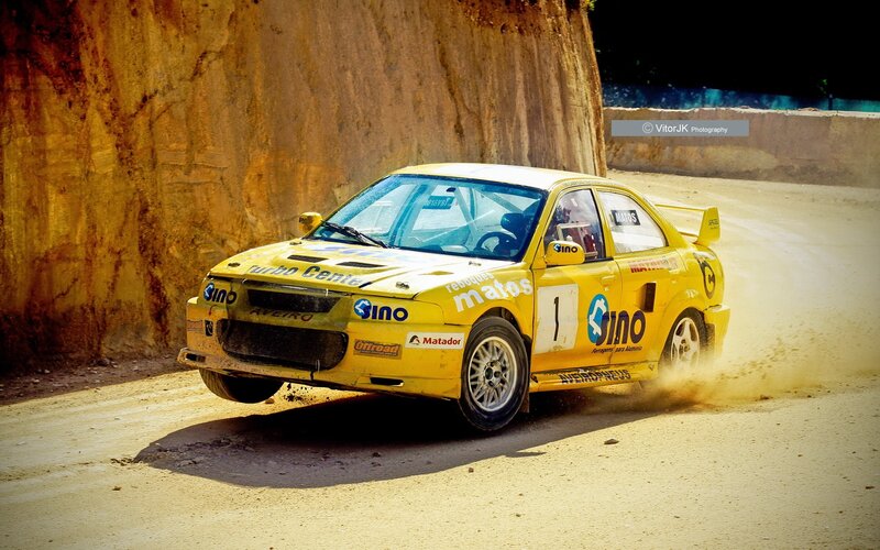 Yellow rally car on dirt track