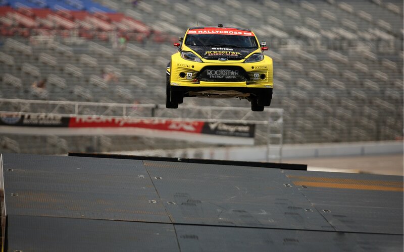 Yellow rallycross car in mid-air