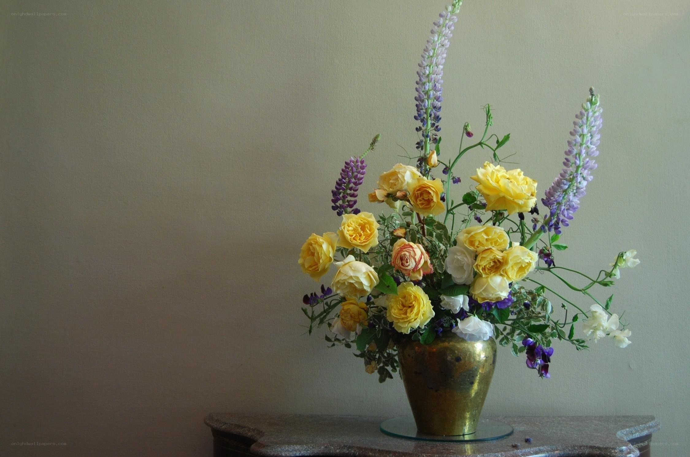 Yellow roses and lupines in vase