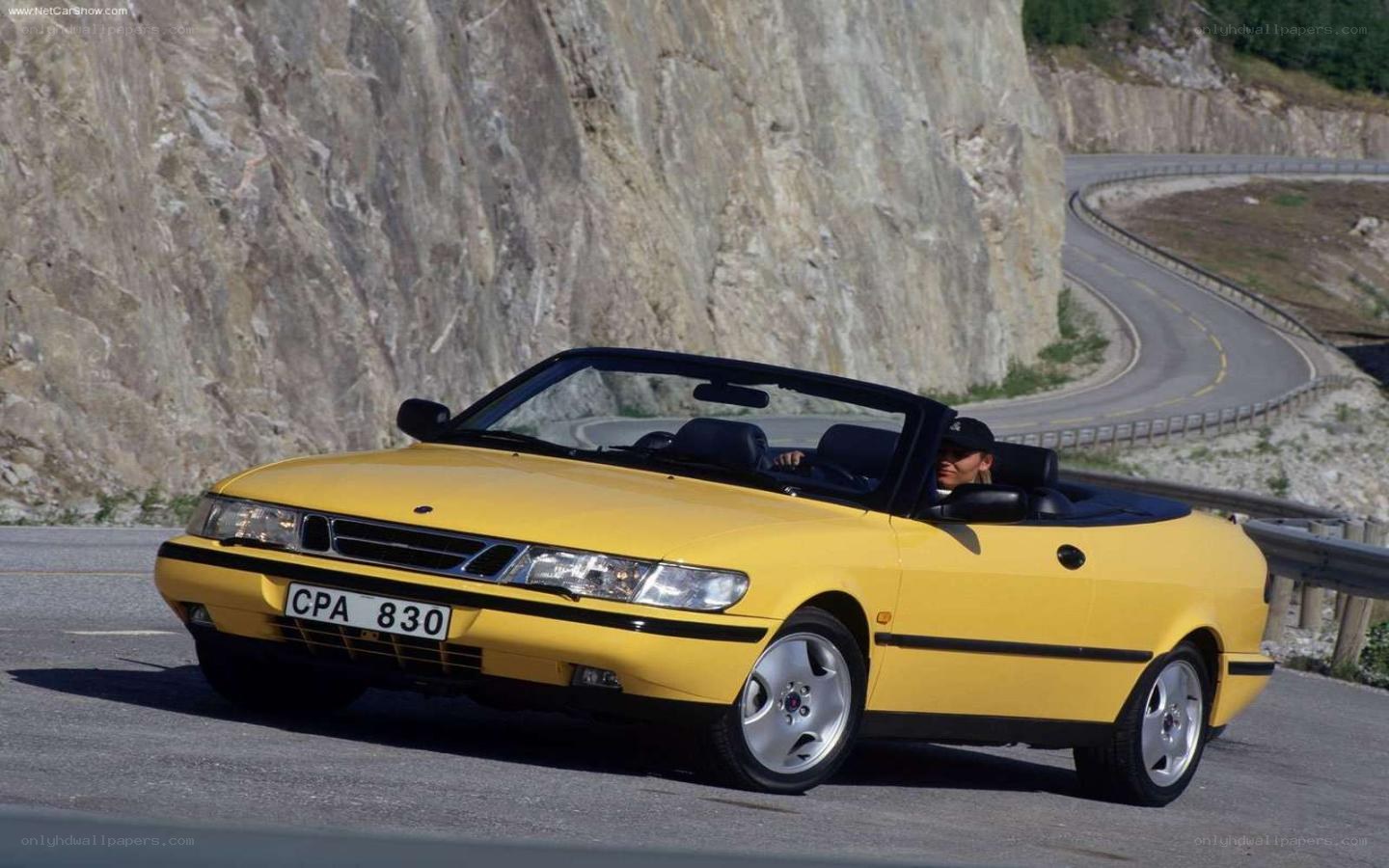 yellow saab convertible on mountain road