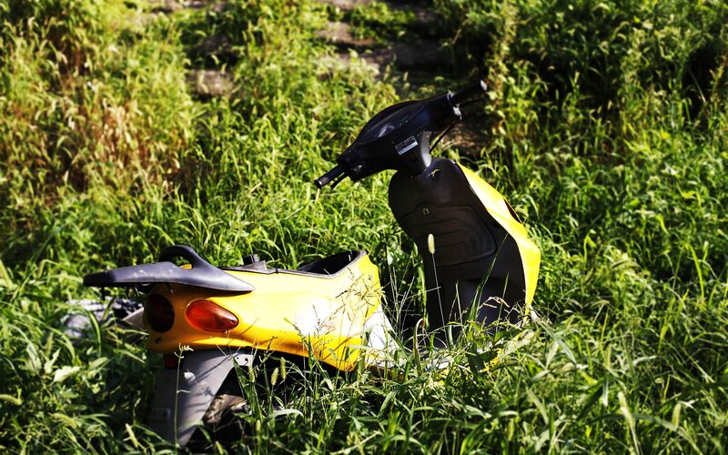 Yellow scooter in tall grass