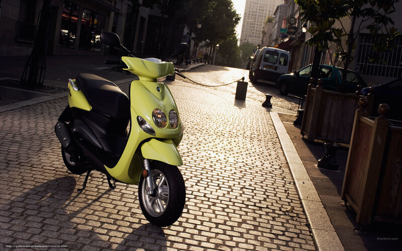 yellow scooter on cobblestone street