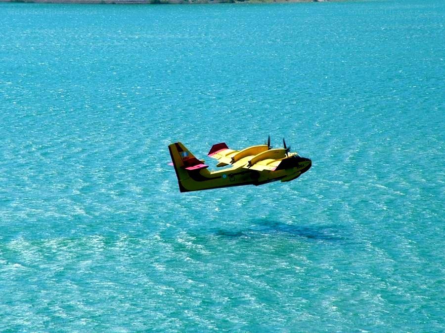 Yellow seaplane over blue water