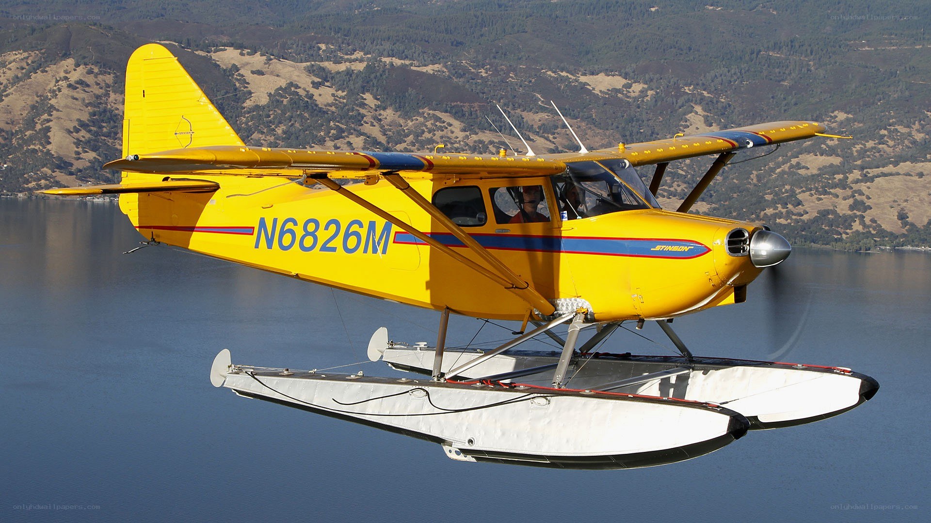 Yellow seaplane over lake
