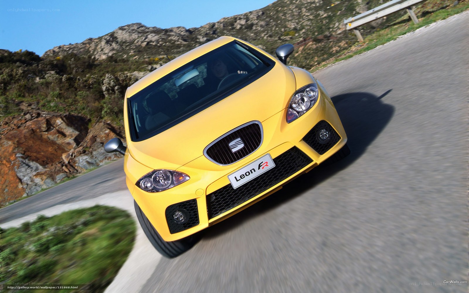 Yellow SEAT Leon FR on a winding road