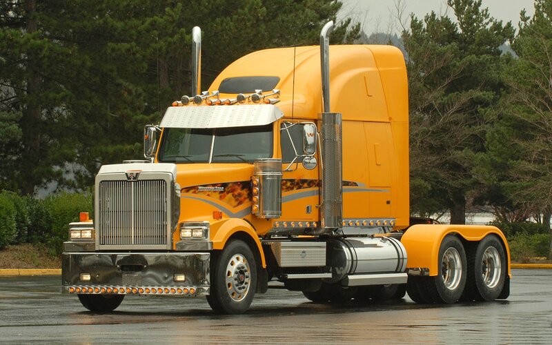 yellow semi-truck on wet pavement