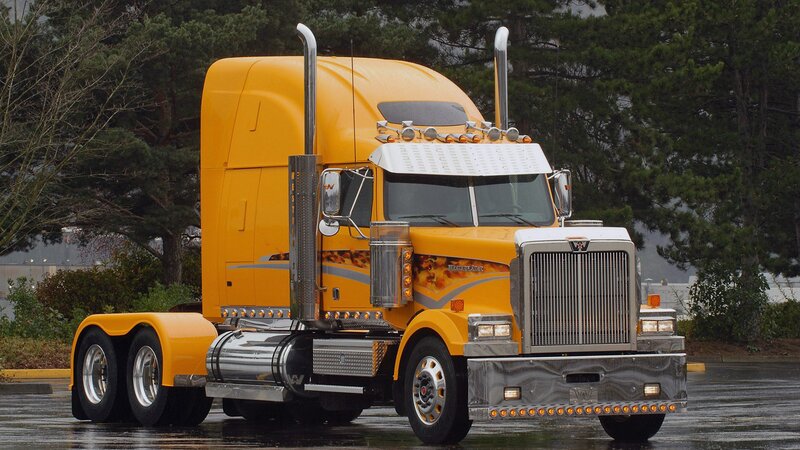 yellow semi-truck on wet pavement
