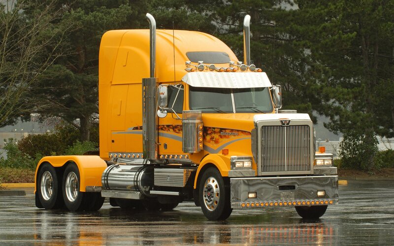 yellow semi-truck on wet pavement