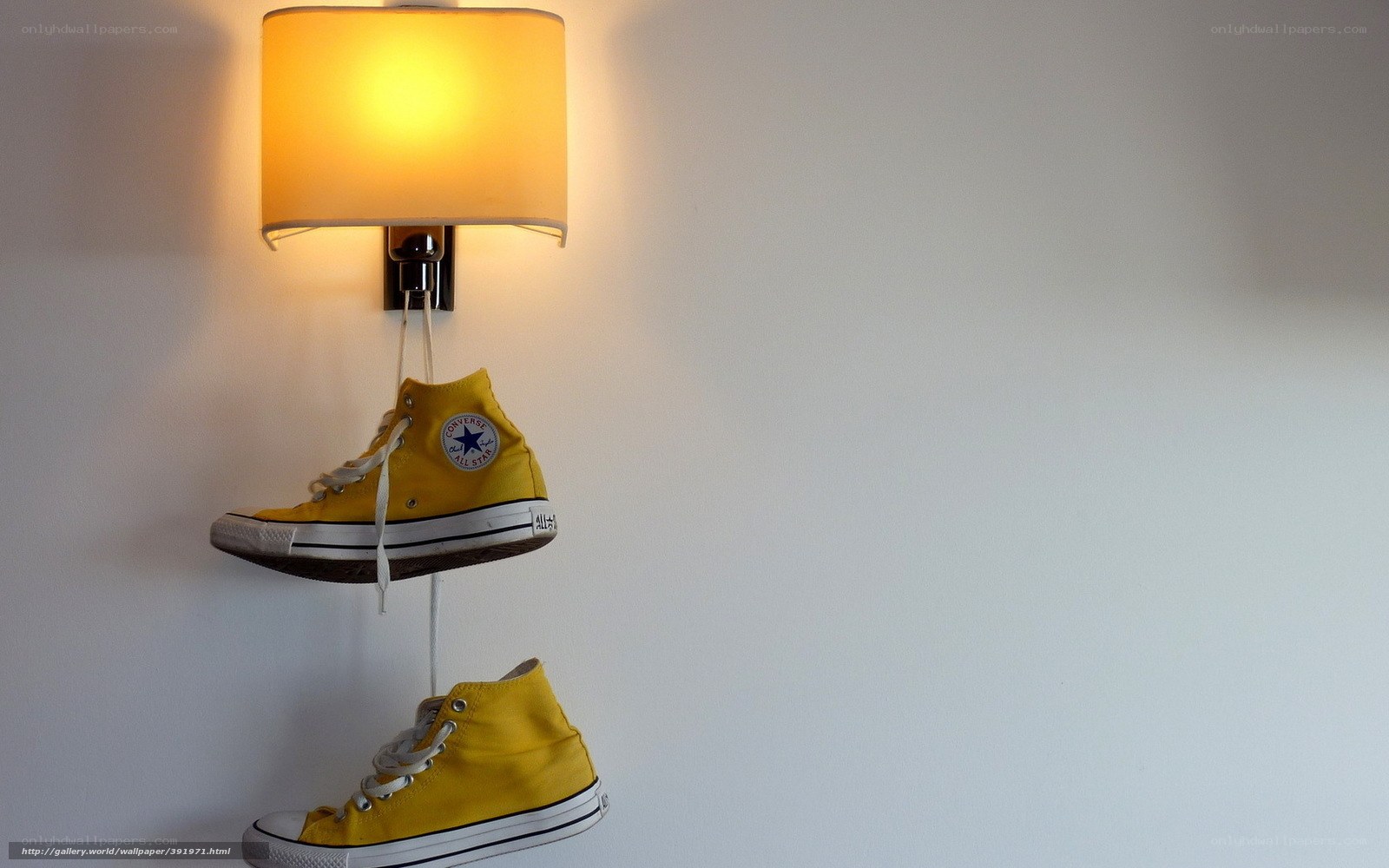 Yellow sneakers hanging from lamp