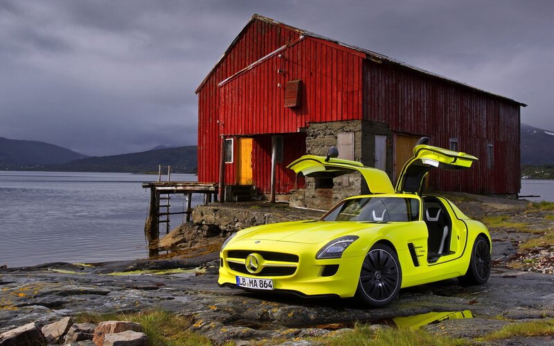Yellow sports car by a red barn