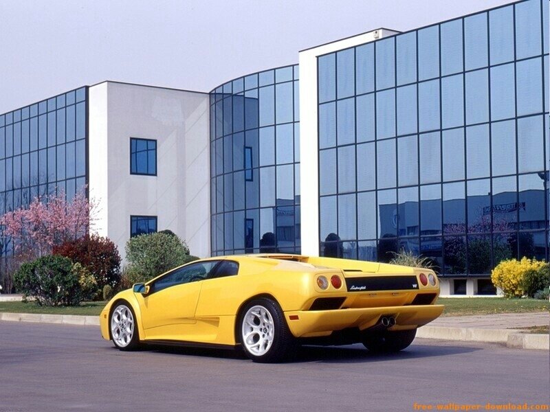 yellow sports car in front of building