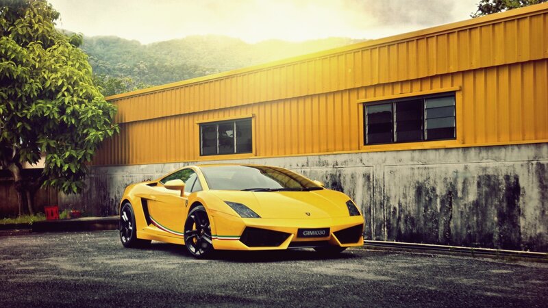 yellow sports car in front of building