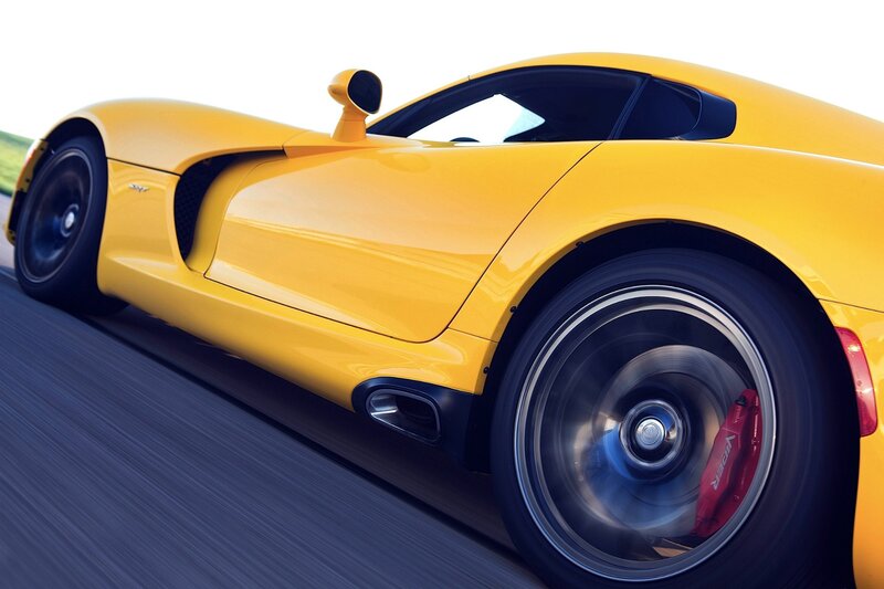 yellow sports car in motion