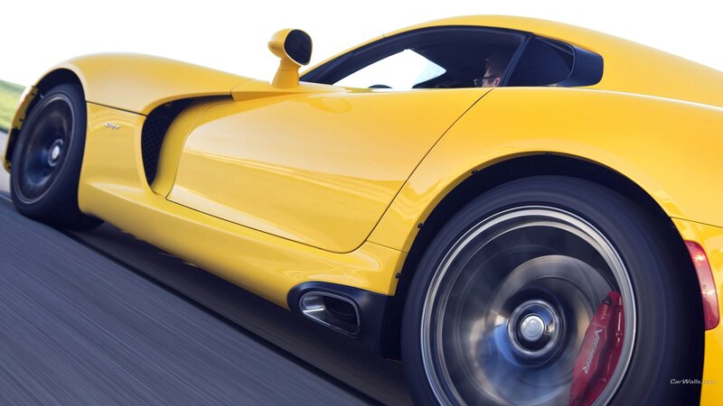 yellow sports car in motion