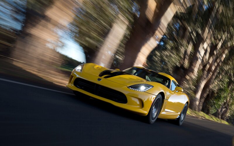 yellow sports car in motion