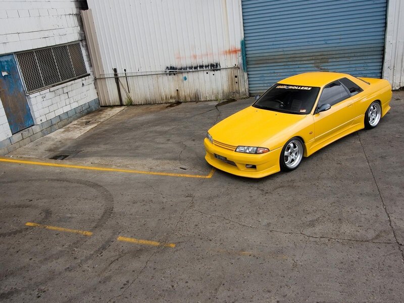 Yellow Sports Car — Industrial, Photograph, Building, Concrete Lot, Roll-up Door, Gray