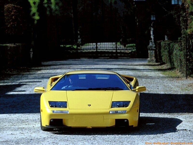 yellow sports car on gravel