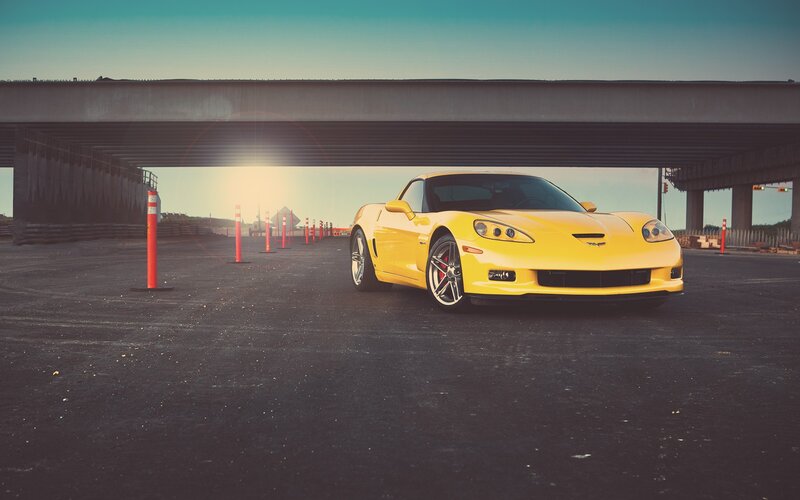 Yellow sports car under overpass