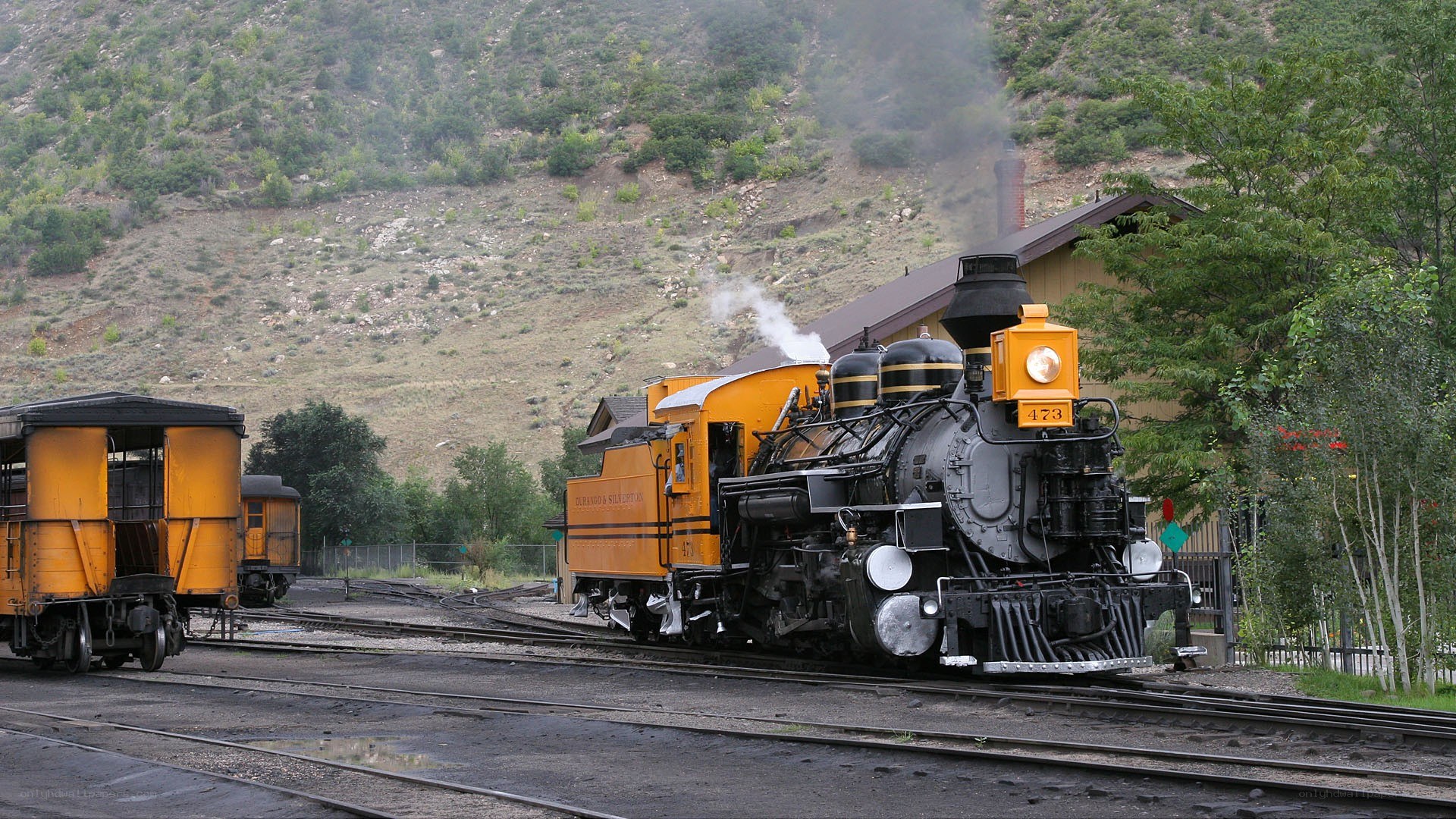 Yellow steam train on tracks