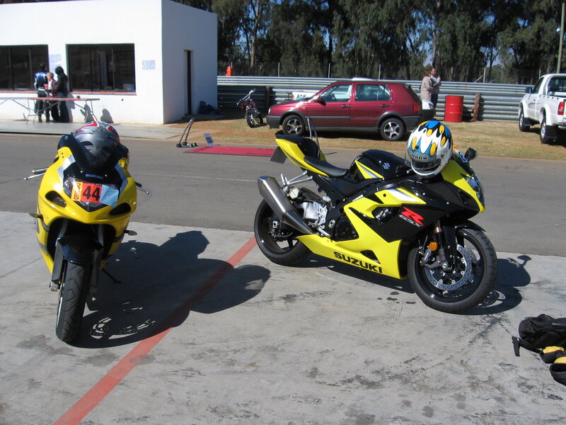 Yellow Suzuki motorcycles at a track