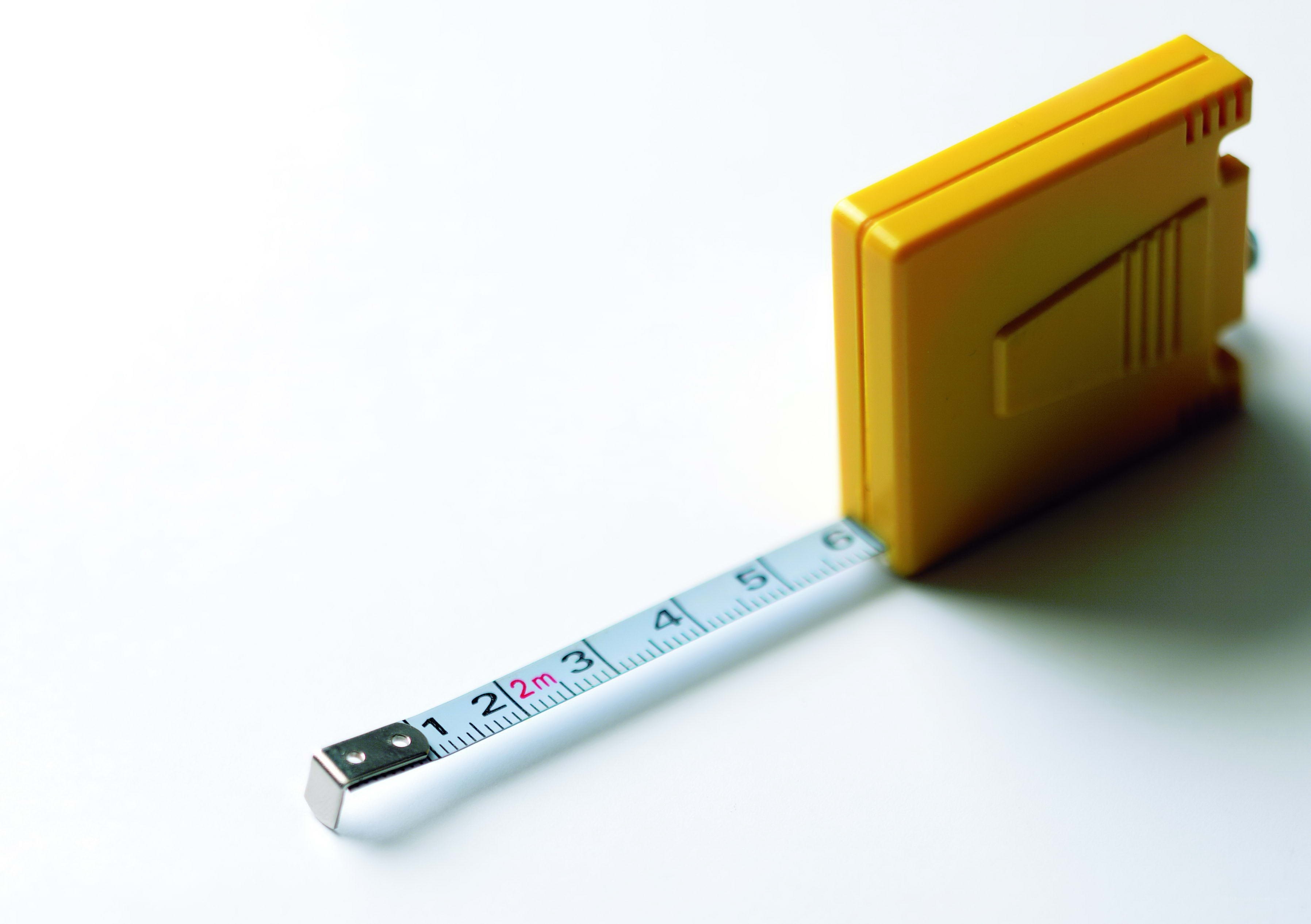Yellow tape measure on white surface
