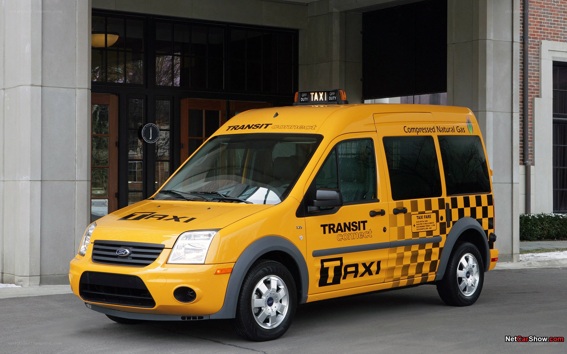 Yellow taxi van parked outside building