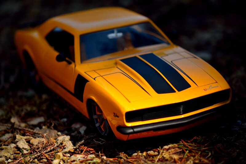Yellow Toy Car — Dramatic, Photograph, Rocks